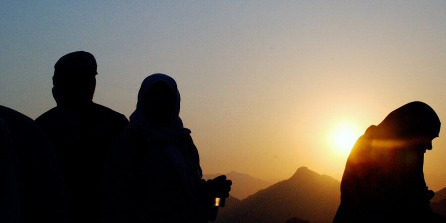 Des personnes qui prient devant un coucher de soleil